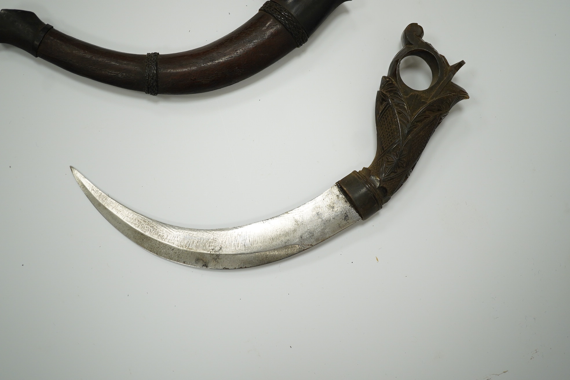 A Korambi sickle dagger in carved wood sheath with horn mounts and horn handle, blade 15cm. Condition - good